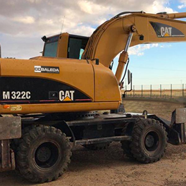 Excavadora de ruedas CAT M322C en obra urbana de Madrid